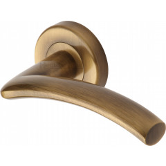 Centaur Curved Lever Handles on Rose in Antique Brass