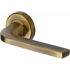 Bellagio Lever Handles on Rose in Antique Brass