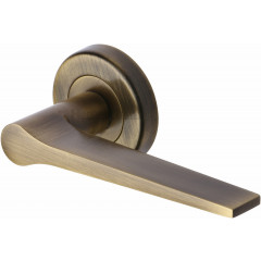 Gio Lever Handles on Rose in Antique Brass