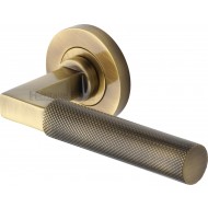 Signac Knurled Lever Handles on Rose in Antique Brass