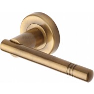 Alicia Bar Lever Handles on Rose in Antique Brass