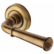 Colonial Regency Lever Handles on Rose in Antique Brass