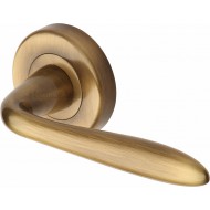 Sutton Lever Handles on Rose in Antique Brass