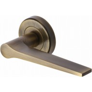 Gio Lever Handles on Rose in Antique Brass